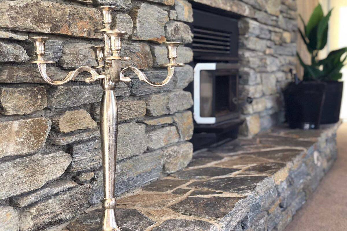 A stone fireplace with a built-in TV and a decorative metal candelabra.