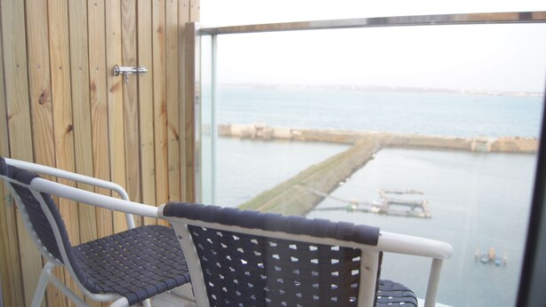 A balcony with a view of a body of water and a dock. - Simple Life Home Stay (Magong)