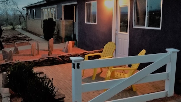 A house with a white gate, a paved driveway, and a small garden area. -  Quiet and Solitude with Magnificent Patio View (Kanab)