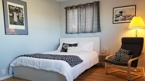A bedroom with a bed, a chair, a lamp, and artwork on the walls. -  Quiet and Solitude with Magnificent Patio View (Kanab)
