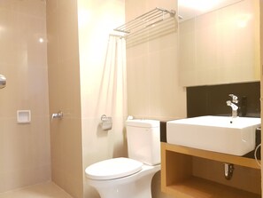 A modern bathroom with a toilet, a sink, and a shower area. - Sun Apartment Semarang (Semarang)
