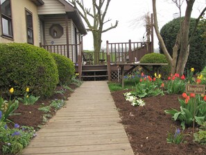 Un sentier en bois menant à une maison dotée d’une terrasse.