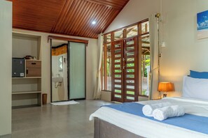 A hotel room with a bed, a desk, a wardrobe, and a bathroom. - The Hawk's Nest Resort (Sabang)