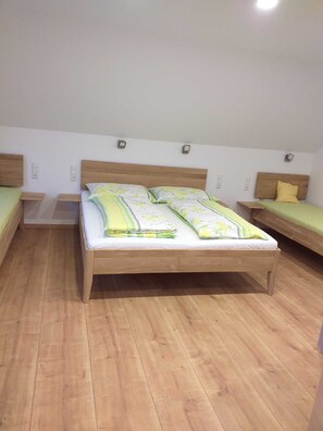 Une chambre à coucher avec un lit en bois, deux tables de chevet et un luminaire fixé au mur.
