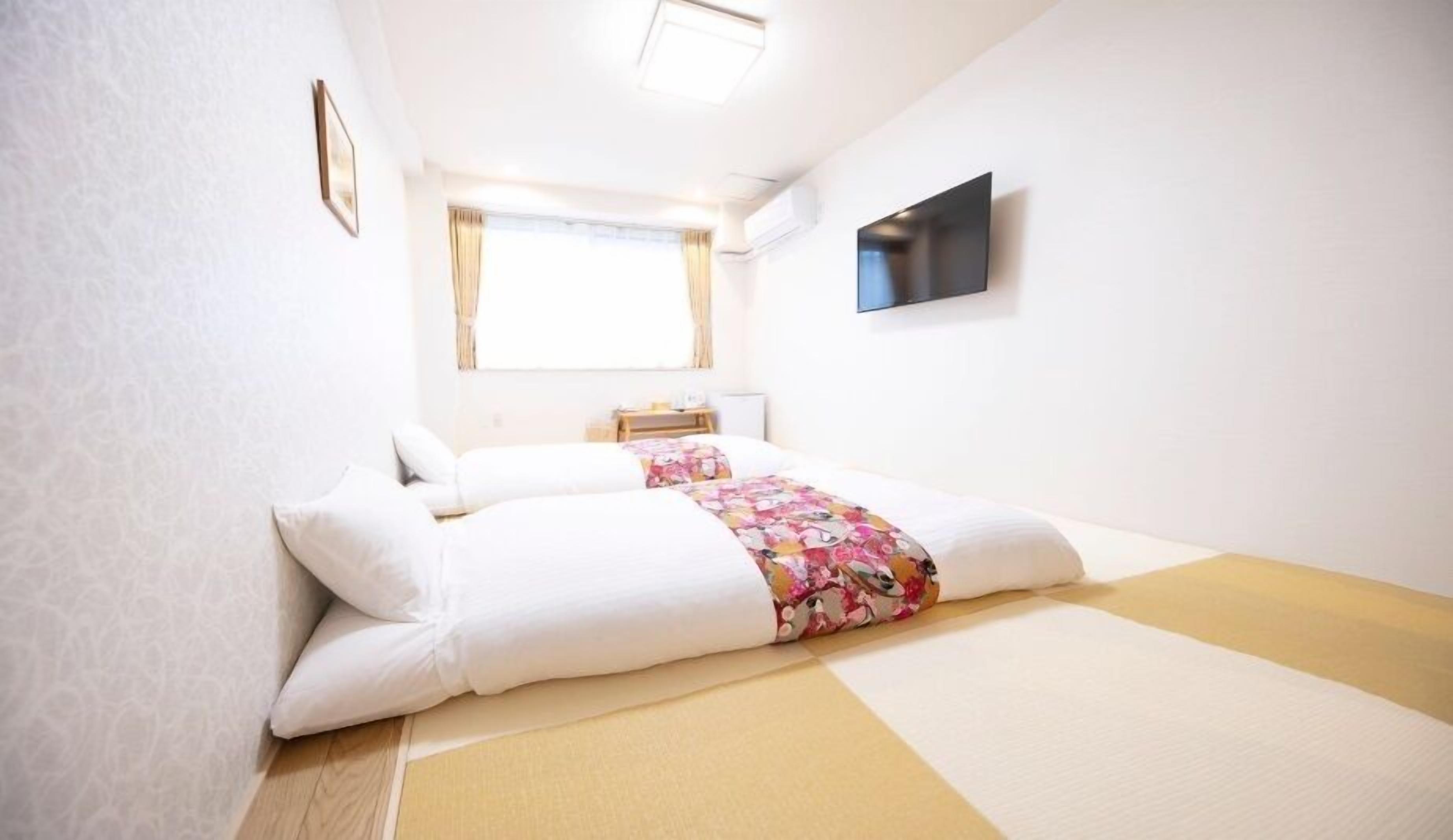 Une chambre avec un lit, une télévision, une fenêtre et une petite table.