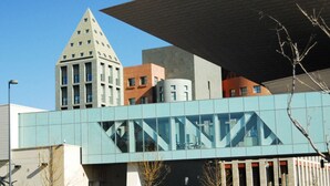 Un bâtiment moderne doté d’une façade en verre et d’une structure triangulaire imposante.