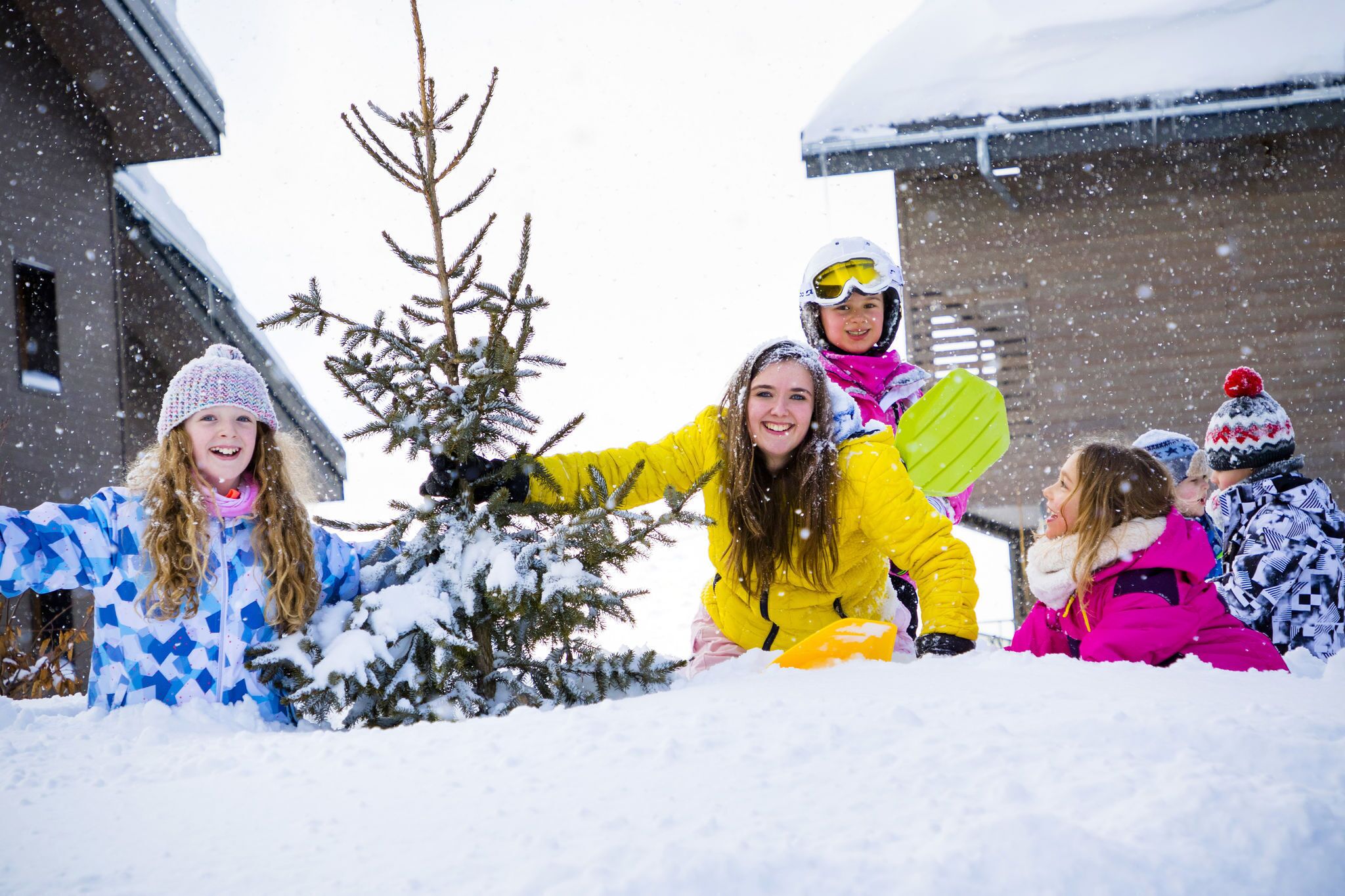 A group of people in winter clothing playing in the snow.