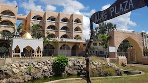 A building with multiple balconies and a sign reading "Alis Plaza". - Alis Plaza (Diani Beach)