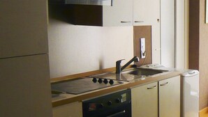 Una cocina compacta con estufa, horno, pileta y microondas.
