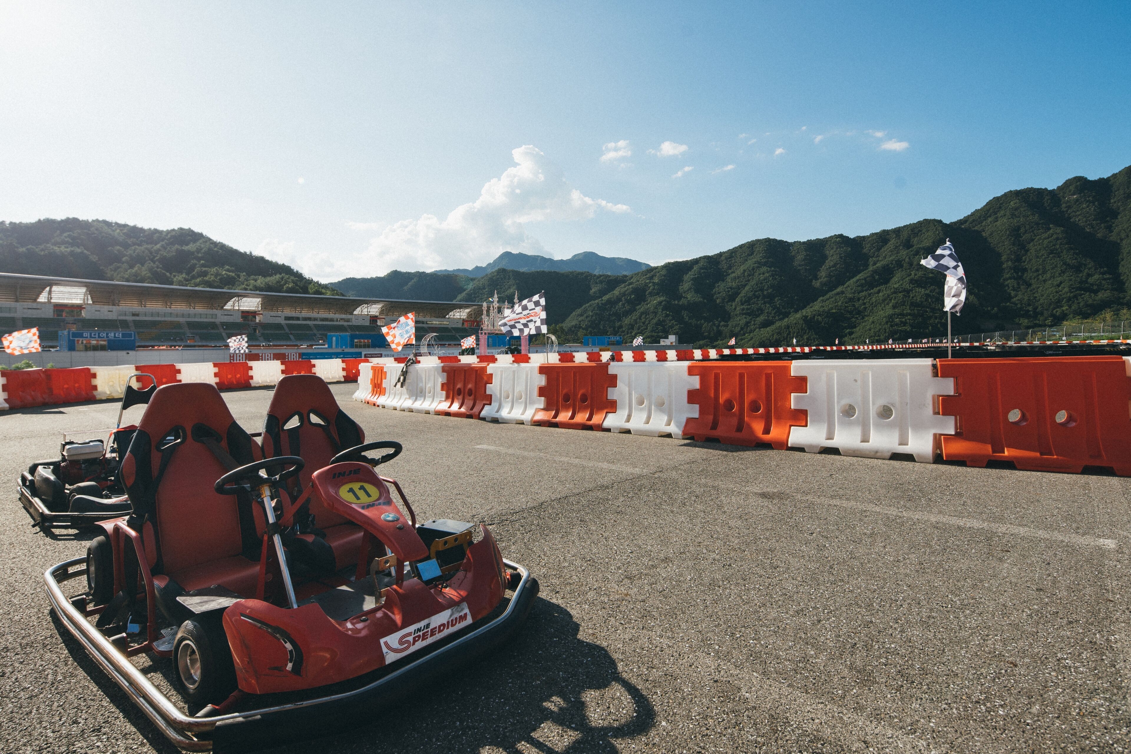 Eine Go-Kart-Bahn mit Absperrungen und einer bergigen Kulisse.