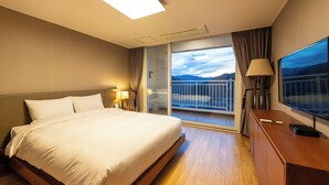 A hotel room with a bed, a TV, a desk, and a balcony with a view of the mountains. - Take Hotel & Resort Inje Speedium (Inje)