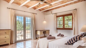 A bedroom with a bed, a desk, a dresser, a ceiling fan, and a window with curtains. - Fantastic Villa with Pool, Wi-Fi, Terrace, Garden and Sea View (Sant Josep de sa Talaia)