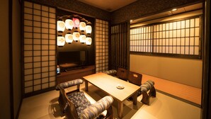Une pièce de style japonais traditionnel, avec un sol recouvert de tatamis, une table basse et des paravents en papier de riz (shoji).