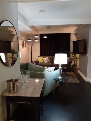 A living room with a sofa, a coffee table, a lamp, and a TV.