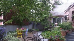 Un espace patio aménagé avec du mobilier d’extérieur, des plantes en pot et un jardin.
