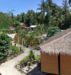 A tropical resort with thatched-roof buildings, lush greenery, and palm trees. - Soeliana Resort (General Luna)