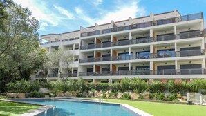 A multi-story hotel with a swimming pool, balconies, and landscaped gardens. - Cosy apartment for 2 guests with WIFI, pool, A/C, TV and terrace (Porto-vecchio)