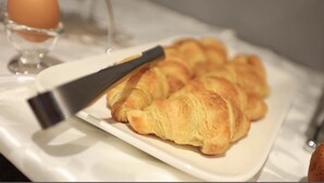 En tallrik med croissanter på ett vitt bordsduksklätt bord.