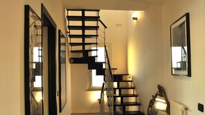 A staircase with a black metal railing leading to an upper floor.