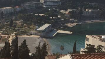 A coastal town with buildings, a beach, and a pier.