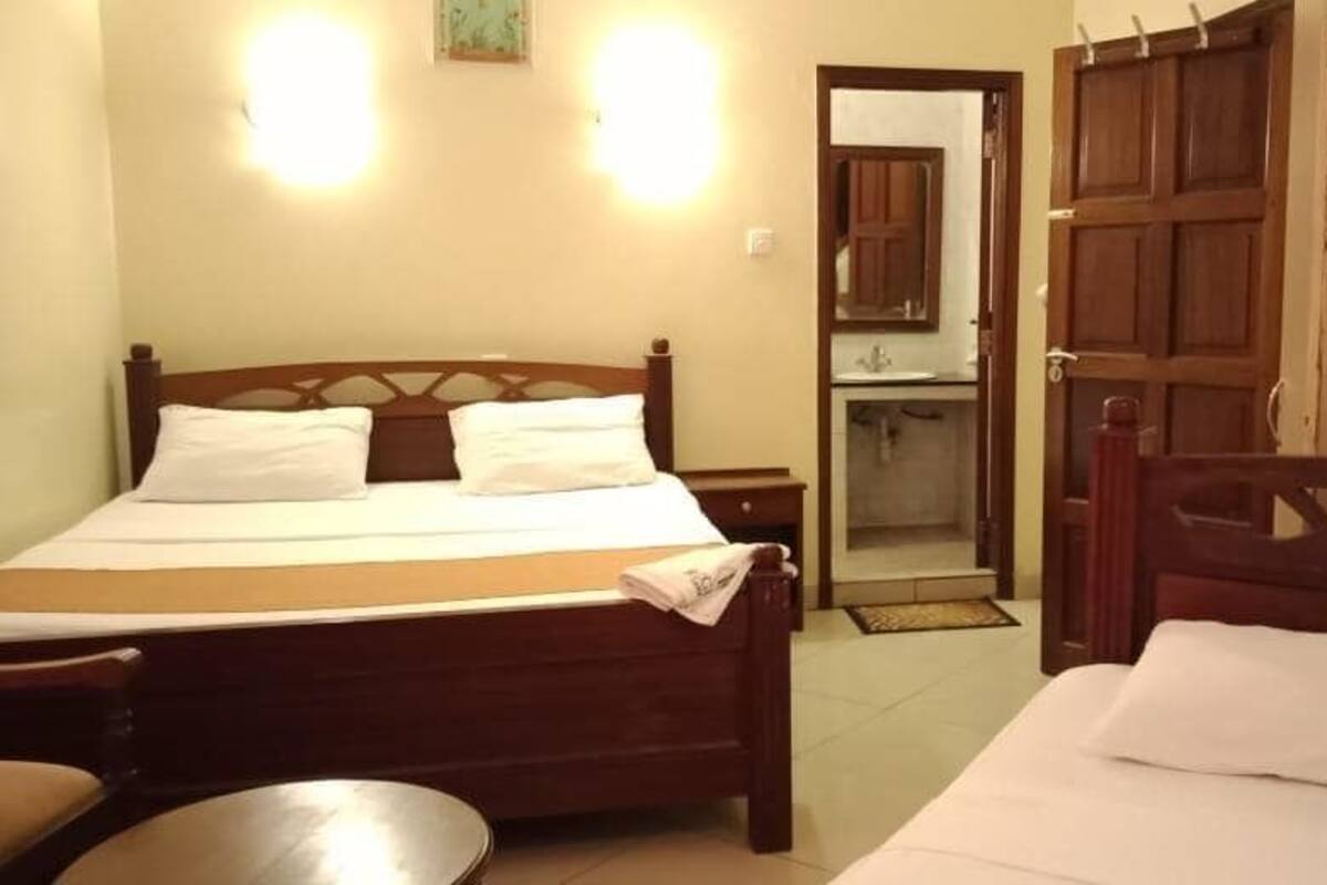 A bedroom with a wooden bed, a bedside table, and a mirror.