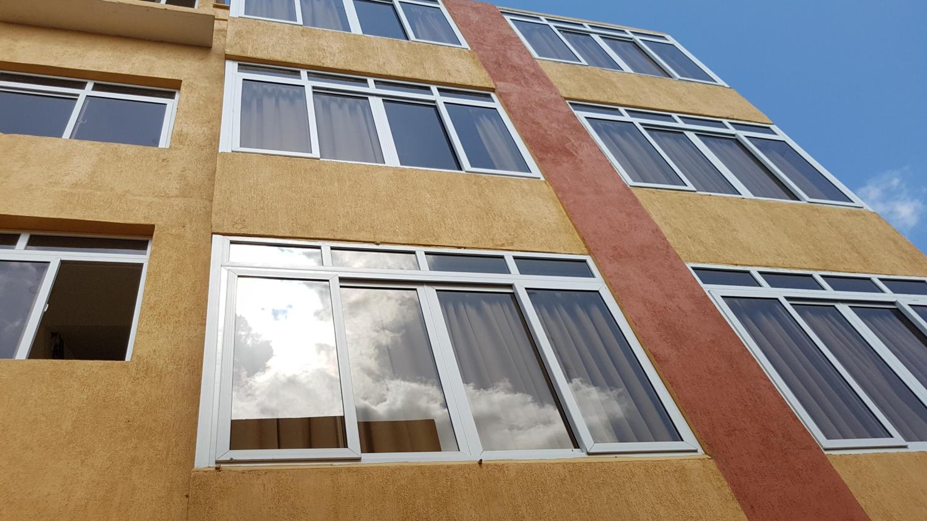 A multi-story building with large windows and a prominent vertical architectural feature.