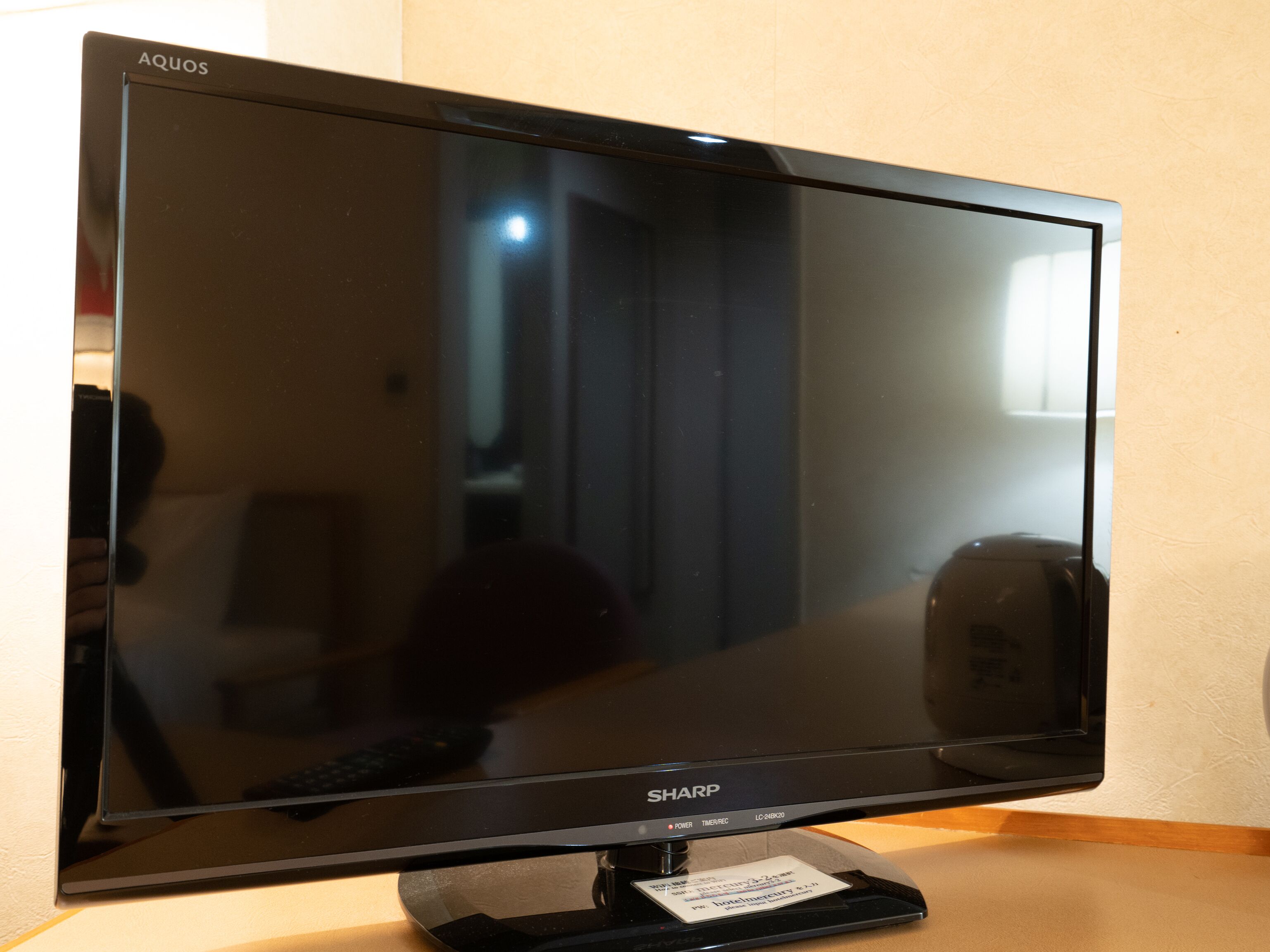 En platt-TV från Sharp, placerad på ett TV-stativ.