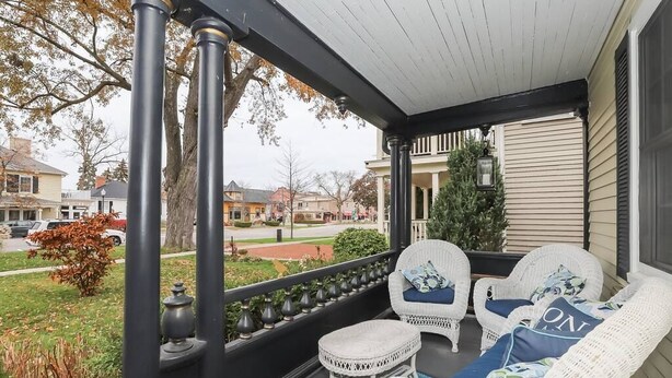 A porch with wicker furniture and a view of the neighborhood. - Meritage House - Excellent Location, King St. NOTL (Niagara-on-the-Lake)