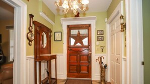 A hallway with a wooden door, a star-shaped window, and a chandelier. - Meritage House - Excellent Location, King St. NOTL (Niagara-on-the-Lake)