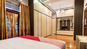 A bedroom with a bed, a TV, and a kitchenette. - OYO 619 Naufal Guest House Syariah (Medan)