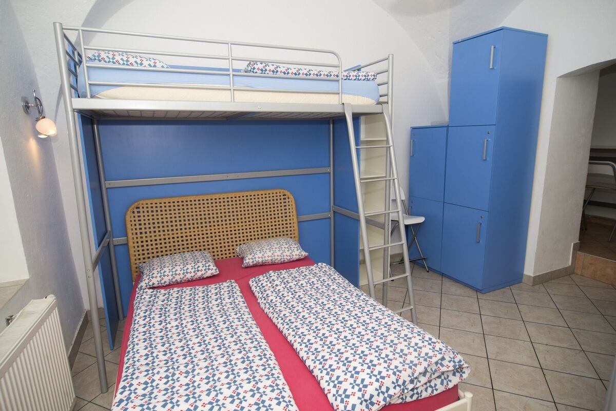 A bunk bed with a ladder, a wardrobe, and a radiator.