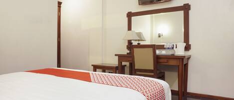 A hotel room with a bed, a desk, a chair, a television, and a mirror.