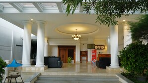 A hotel entrance with a grand staircase, white columns, and a reception desk. - Super OYO OYO Capital O 514 Omah Pari Boutique Hotel (Yogyakarta)