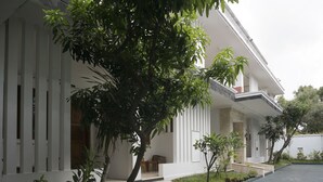 A modern building with a covered porch, potted plants, and a stone pathway leading to the entrance. - Super OYO OYO Capital O 514 Omah Pari Boutique Hotel (Yogyakarta)