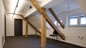 A room with exposed wooden beams, a door, a chair, and a window. - Cha Cha Rooms (Ljubljana)