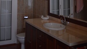 A bathroom with a sink, mirror, and toilet. - Villa Remedios, whole house located in rural environment. (Málaga)