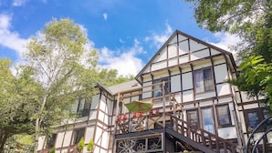 A traditional half-timbered house with a balcony and a staircase leading to the entrance. - Pension Wildflowers (Tateshina)