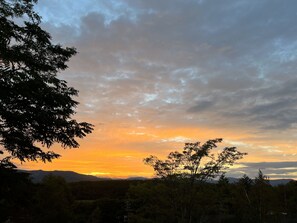 A sunset view with mountains in the background and trees in the foreground. - Pension Wildflowers (Tateshina)