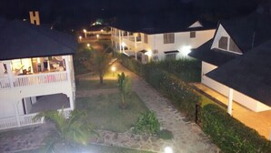 A row of white buildings with flat roofs and a central pathway. - Morning Star Diani (Diani Beach)