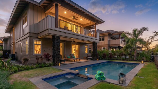 A two-story house with a large balcony, a swimming pool, and a well-maintained garden. - Stunning 4BR KaMilo Home 349 at Mauna Lani – Relaxed Elegance & Pool/Spa (Kamuela)