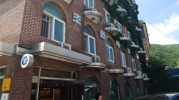 A multi-story hotel with a brick facade, large windows, and balconies. - Green Resortel (Sokcho)