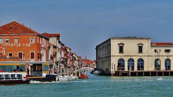 A canal with buildings on either side, a boat, and a bridge in the background.