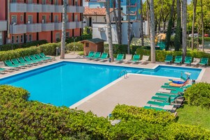 Una piscina techada, una piscina al aire libre de temporada, sombrillas