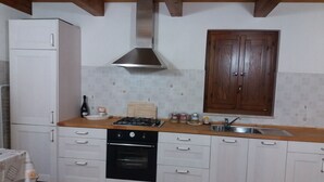 A kitchen with white cabinets, a wooden countertop, a gas stove, a stainless steel range hood, and a wooden cabinet above the sink. - Country house with pool, renovated and well furnished (San Lorenzo)
