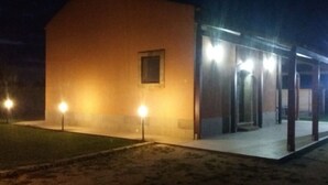A building with a single visible window and a covered outdoor area with lights. - Country house with pool, renovated and well furnished (San Lorenzo)