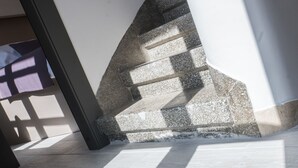 Una escalera moderna con un diseño geométrico que conduce a un piso superior.