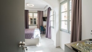Una habitación de hotel con cama, escritorio, silla y televisión.