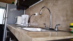 A kitchen with a stainless steel sink, a coffee maker, and a toaster. - Apart. Valhalla San Ramon (San Ramón)