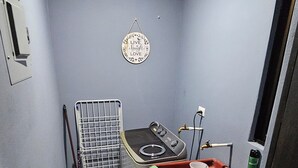 A small, narrow bathroom with a sink, a mirror, and a shower area. There is a towel hanging on the wall and a small shelf with toiletries. - Apart. Valhalla San Ramon (San Ramón)
