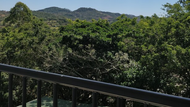 A balcony with a view of a green landscape and mountains under a partly cloudy sky. - Apart. Valhalla San Ramon (San Ramón)